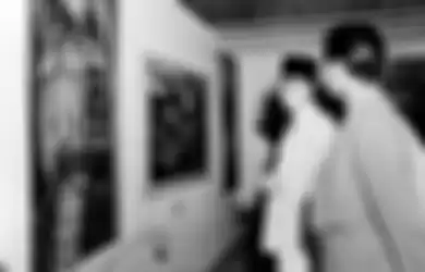 Presiden Soekarno pada suatu kunjungan pameran lukisan di Jakarta, mengamati lukisan 'Sumilah' karya