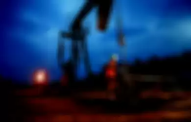 Seorang pekerja melakukan pengecekan pompa angguk yang digunakan untuk mengeksploitasi minyak bumi d
