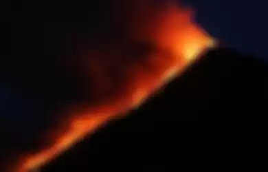 Lava pijar meluncur dari kawah Gunung Api Karangetang saat erupsi.