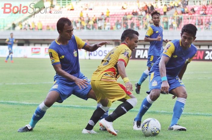 Gelandang Mitra Kukar Hendra Bayauw (tengah) dikepung dua pemain Bhayangkara FC dalam duel Grup B Piala Presiden 2019 di Stadion Patriot, Kota Bekasi, Senin (11/3/2019) sore WIB. Bhayangkara FC menang 2-1. 