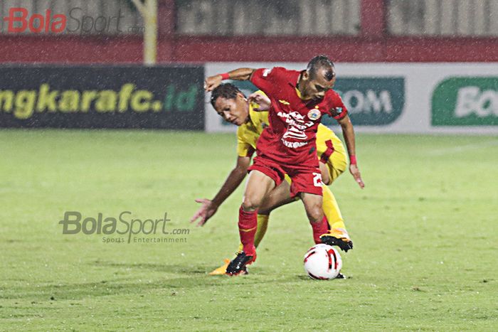 Riko Simanjuntak sedang berebut bola dengan Adam Alis ketika pertandingan Bhayangkara FC melawan Persija Jakarta  di Stadion PTIK, Melawai, Jakarta Selatan (14/3/2020)
