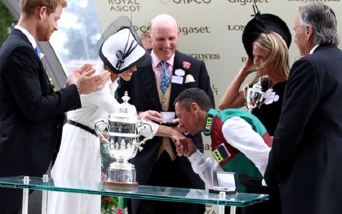 Jockey Frankie Dettori is presented with the trophy by the Duke and Duchess of Sussex after winning 