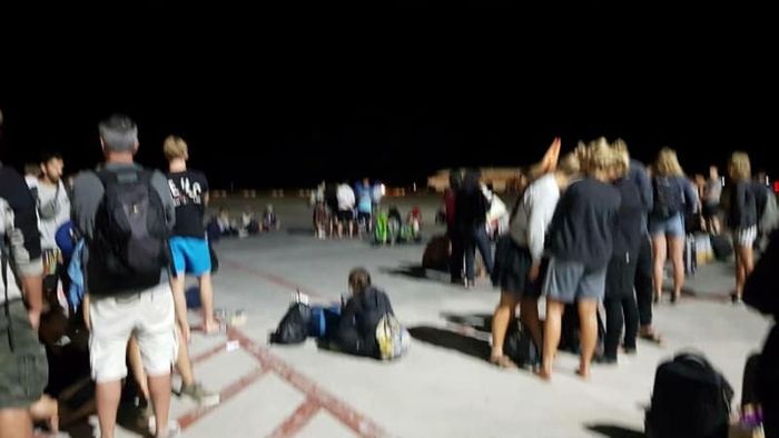 
penumpang di Bandara Ngurah Rai menunggu di luar bangunan bandara