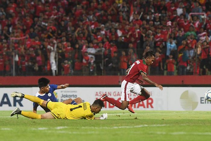 Pesepak bola Indonesia U-16 Mochammad Supriadi (kanan) berusaha melewati penjaga gawang Filipina