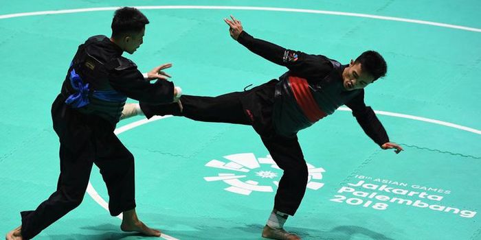 Atlet pencak silat Indonesia, Abdul Malik (kanan) melawan atlet pencak silat Vietnam (kiri).