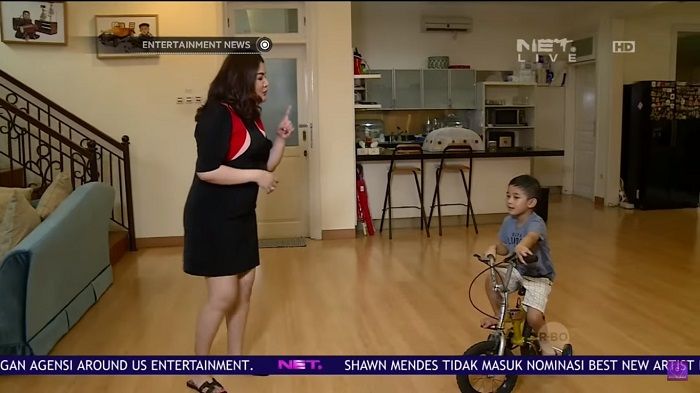 Anak Nindy Ayunda sedang bermain sepeda di ruang tengah