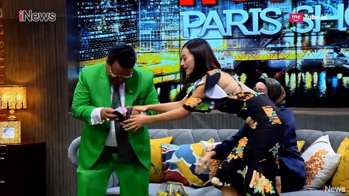Lolita berusah menunjukkan pada kamera dan Shinta Bachir kalau dompet Hotman Paris jebol