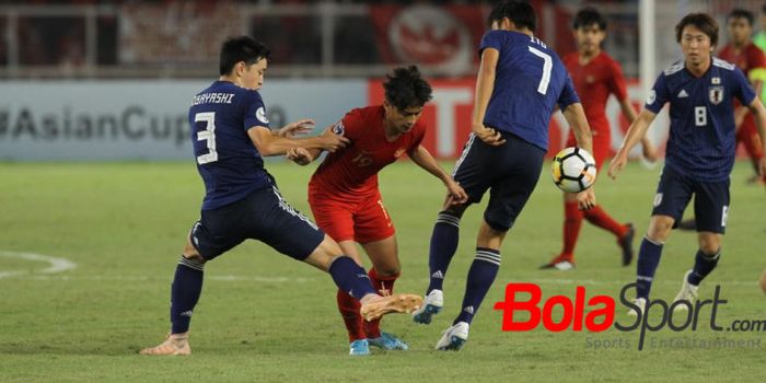 Penyerang timnas U-19 Indonesia, Hanis Saghara Putra diapit dua pemain timnas U-19 Jepang, Yuki Koba