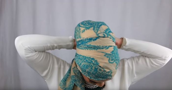 Masukkan sisa hijab yang disilangkan ke bagian bawah turban