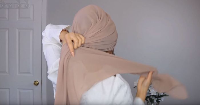 Arahkan ujung pashmina ke bagian belakang