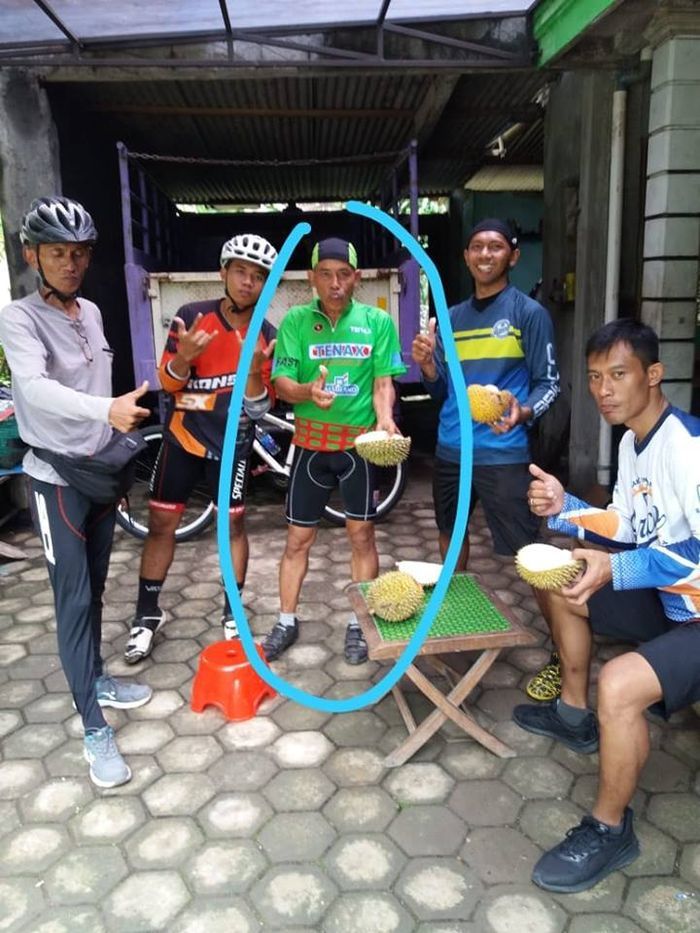 Pesepeda menikmati waktu istirahat sambil makan durian