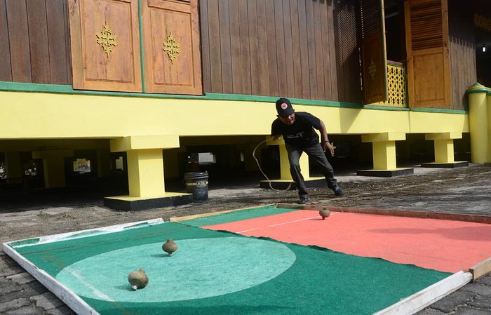Permainan gasing tradisional di halaman Balai Adat Pulau Penyengat.