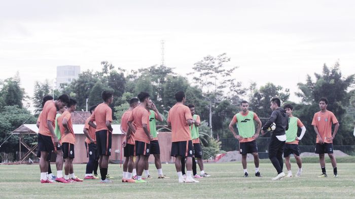 Pelatih PSS Sleman, Seto Nurdiantoro, sedang memberikan pengarahan kepada para pemain saat sesi latihan.