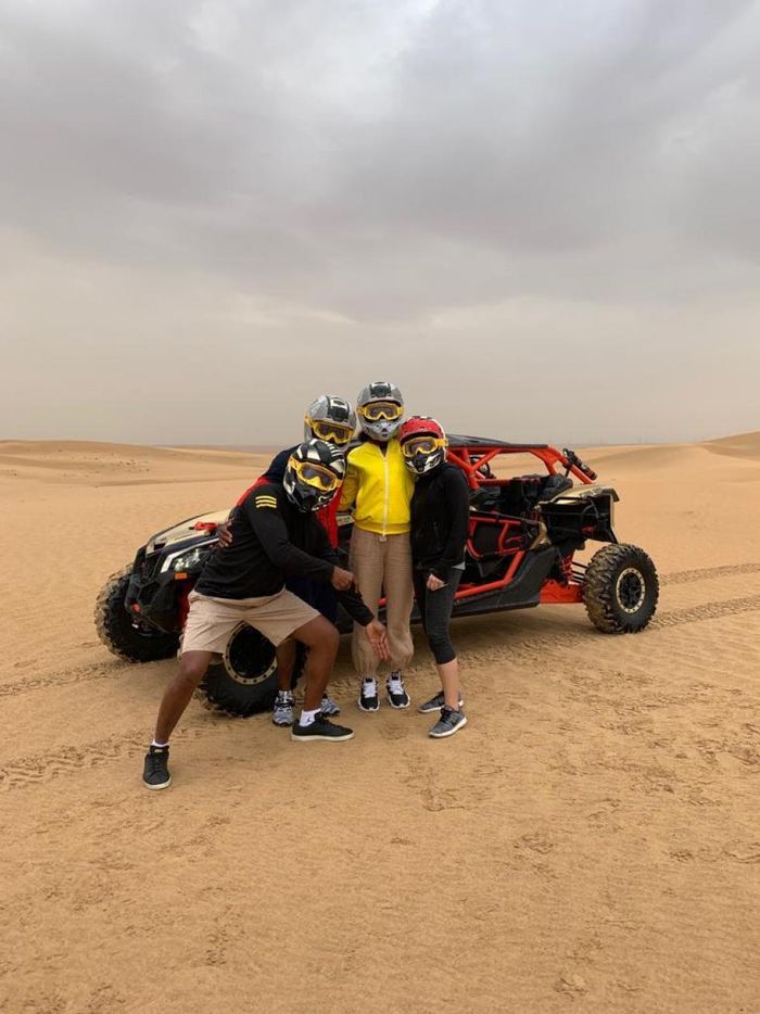 Petenis nomor satu dunia, Naomi Osaka (tengah), berpose di tengah kegiatannya menjelajah gurun di Dubai.