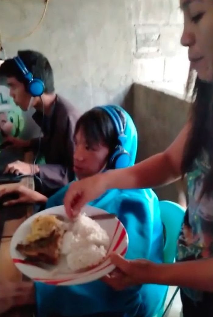 Tak mau anaknya sakit, seorang ibu suapi sang anak di warnet