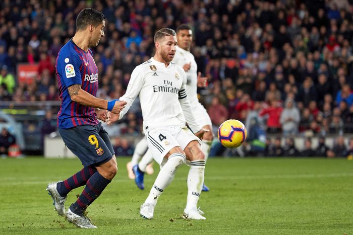 Kapten Real Madrid, Sergio Ramos, berupaya mengontrol bola saat dijaga pemain Barcelona, Luis Suarez, pada laga El Clasico, Oktober 2018.     