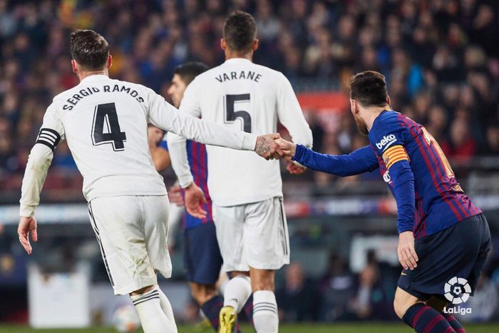 Kapten Real Madrid, Sergio Ramos (kiri), menarik tangan bintang Barcelona, Lionel Messi.