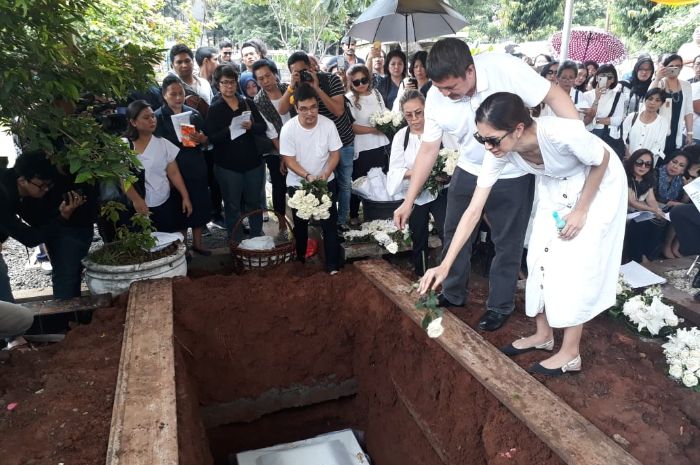 Mikha Tambayong dan keluarganya menabur puluhan mawar putih ke dalam kuburan ibunda Mikha.