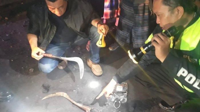 Kasatreskrim Polres Lumajang AKP Hasran (kiri) memeriksa celurit barang bukti aksi carok di TKP.