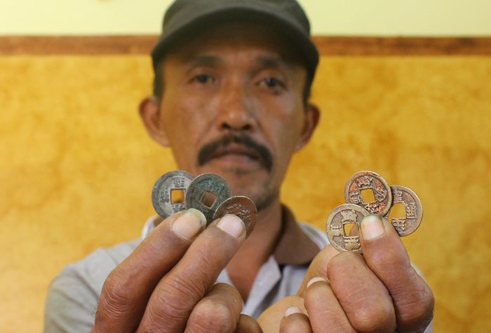Benda purbakala berupa koin yang ditemukan di lokasi pembangunan Tol Pandaan-Malang seksi 5 kilometer ke-37 Desa Sekarpuro, Kecamatan Pakis, Kabupaten Malang, Minggu (10/3/2019). Benda-benda dari situs purbakala itu diduga merupakan peninggalan masa Kerajaan Majapahit.
