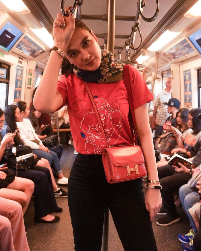 Penampilan simpel Luna Maya naik kereta pakai tas branded koleksi Hermès Constance 24 Bag Rouge Casaque Epsom