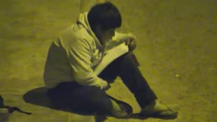 Victor Martin Angulo Cordoba mengerjakan PR di bawah penerangan lampu jalan.