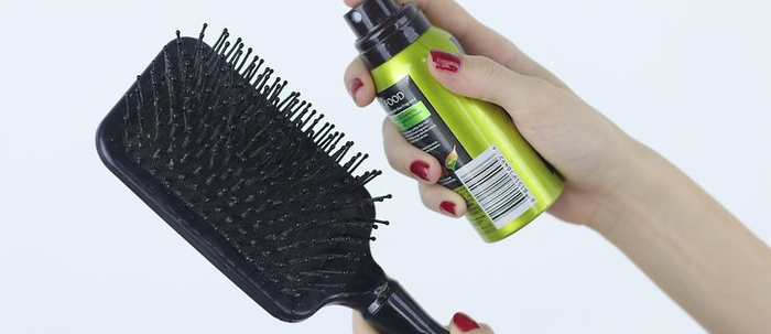 Menyemprotkan hair spray ke sisir
