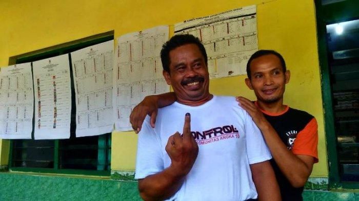 Nurhadi berpose menggunakan kaos KONTROL setelah menggunakan hak pilihnya.