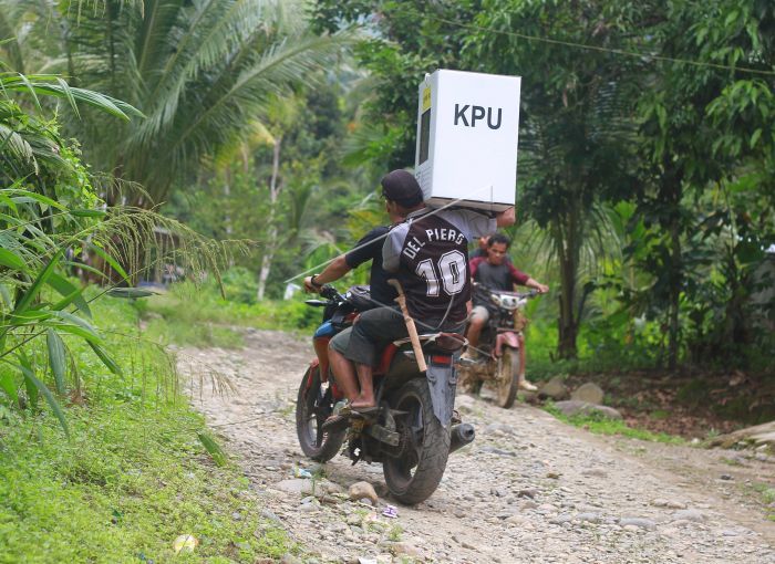 Petugas mengendarai sepeda motor menuju TPS.