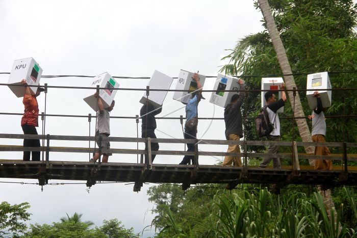 Petugas melintasi Jembatan Gantung.