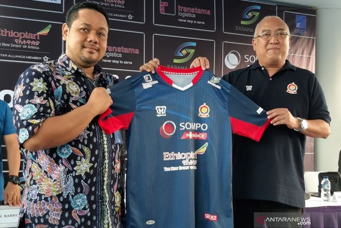 Direktur Utama sekolah sepak bola (SSB) asal Indonesia Akademi Sepak Bola Intinusa Olah Prima (ASIOP), Ade Prima Syarif (kanan), menyerahkan seragam kandang terbaru ASIOP kepada pihak sponsor di Kantor ASIOP, Jakarta, Jumat (3/5/2019).