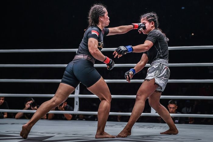 Atlet ONE Championship asal Indonesia, Priscilla Hertati Lumban Gaol (kiri), melepaskan pukulan ke petarung Kamboja, Nou Srey Pov, dalam ONE: For Honor di Istora Senayan, Jumat (3/5/2019).
