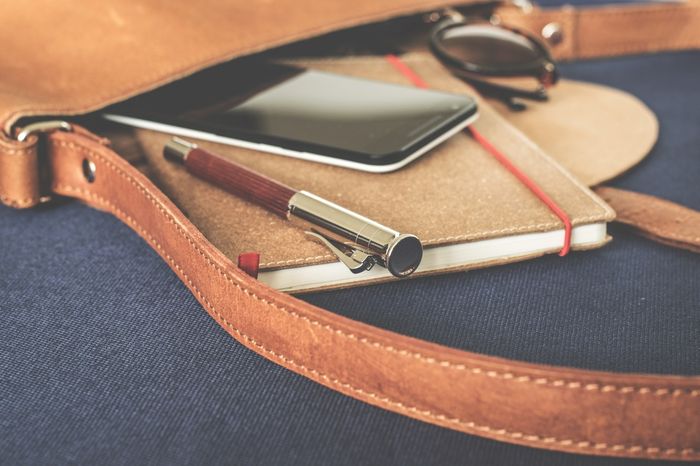 Menaruh handphone di dalam tas