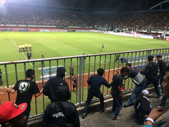 Suporter PSS Sleman mencoba melakukan kekerasan ke pemain Arema FC.