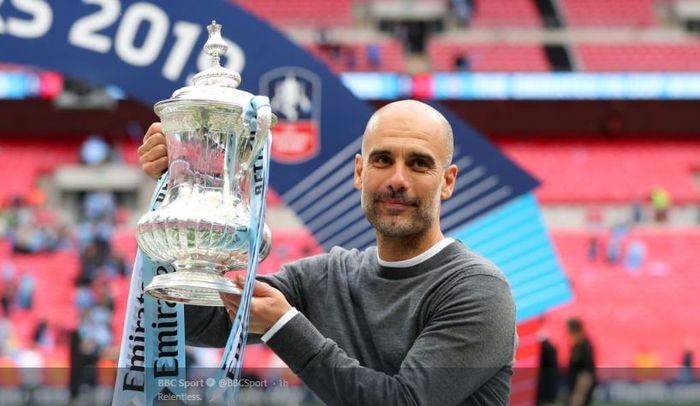 Manajer Manchester City, Pep Guardiola, bersama trofi Piala FA musim 2018-2019.