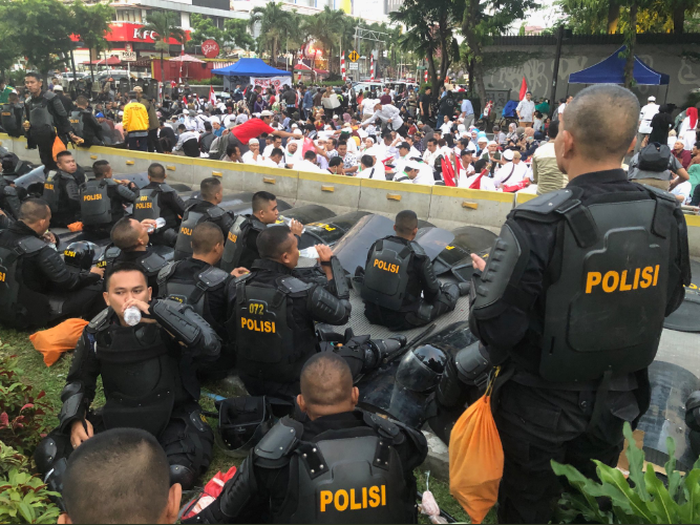 Polisi dan demonstran buka puasa bersama di tengah jalan.