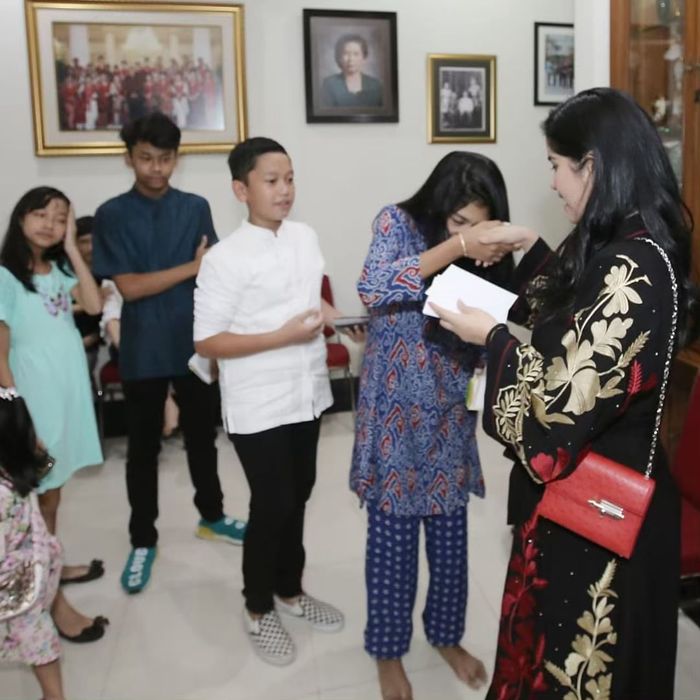 Annisa Pohan terlihat membawa sebuah tas mungil bernuansa warna merah