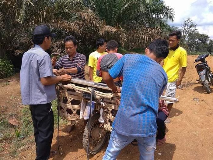 Warga bergotong royong membuat alas untuk jenazah.