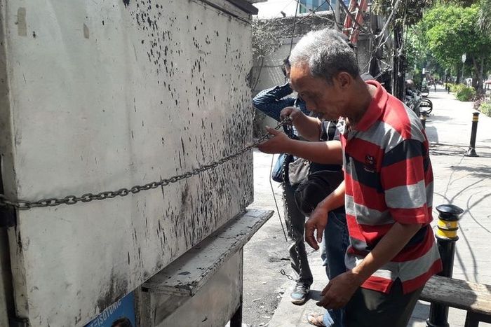 Usma, pemilik warung di Jalan KH Wahid Hasyim menutup warungnya yang dijarah massa.