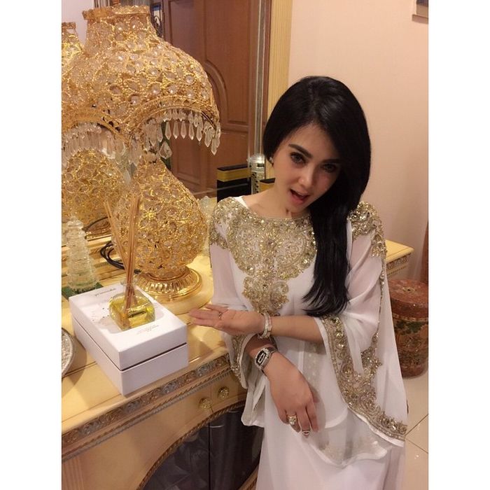 Syahrini terlihat mengenakan busana model kaftan berwarna putih