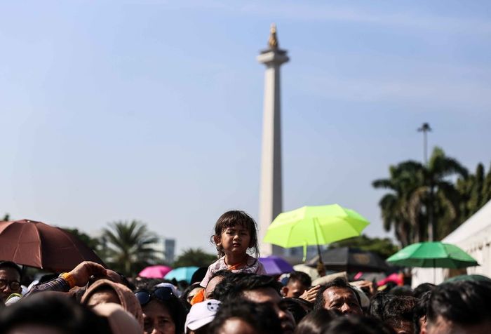 Warga menunggu giliran masuk ke Istana Negara di pintu sebelah barat Monumen Nasional (Monas), Jakarta Pusat, Rabu (5/6/2019). Mereka datang untuk mengucapkan selamat Idul Fitri kepada Presiden Joko Widodo.