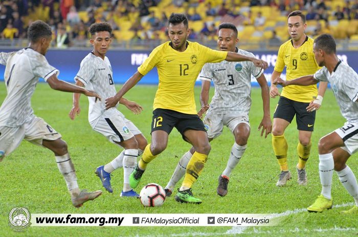 Gelandang timnas Malaysia, Akram Mahinan (12) di antara empat pemain timnas Timor Leste pada laga leg pertama fase awal Kualifikasi Piala Dunia 2022/Piala Asia 2023 di Stadion Nasional Bukit Jalil, Kuala Lumpur pada 7 Juni 2019. 