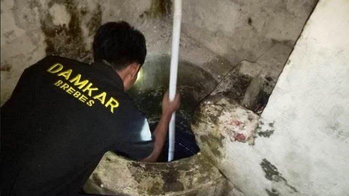 Tim SAR dibantu Polsek dan Koramil Brebes mengevakuasi jasad Prasetiyo yang tercebur ke dalam sumur Toko Optik Mitra di RT 4 RW 19, Jalan Pusponegoro Kelurahan Brebes, Kecamatan Brebes, Selasa (11/6/2019) malam.