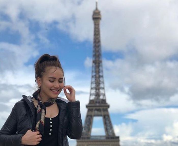 Ayu Ting Ting tampak berfoto di depan Menara Eiffel
