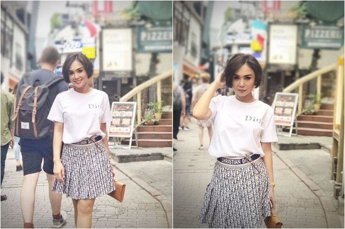 Gaya simpel Yuni Shara ketika mengenakan kaus polos putih dengan rok rimpel merek Christian Dior