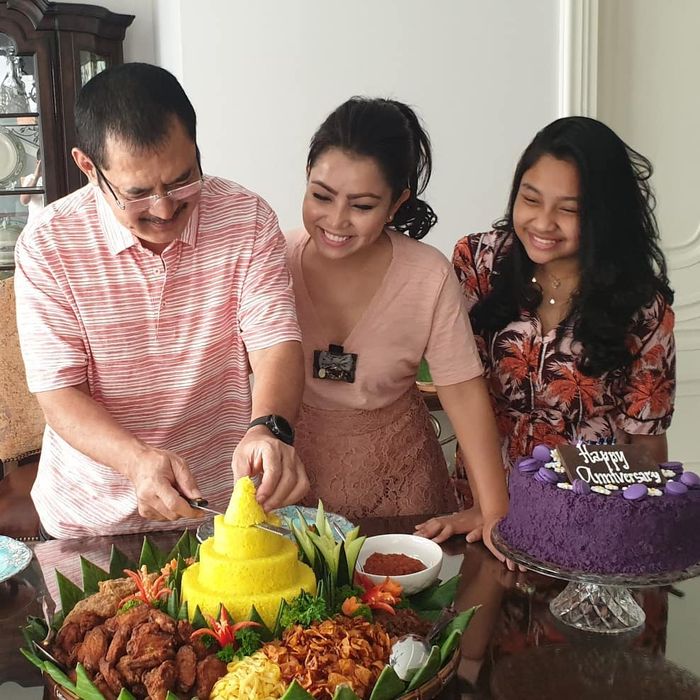 Mayangsari terlihat mengenakan atasan t-shirt dengan model kerah v-neck bernuansa warna pink saat rayakan hari Anniversary