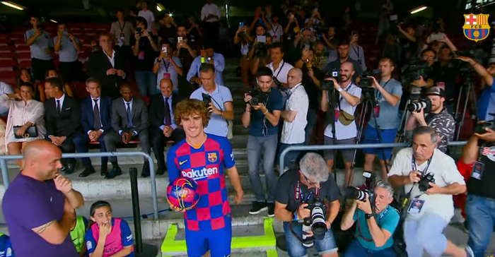 Striker timnas Prancis, Antoine Griezmann, hendak masuk lapangan Stadion Camp Nou untuk diperkenalkan sebagai penggawa baru Barcelona.