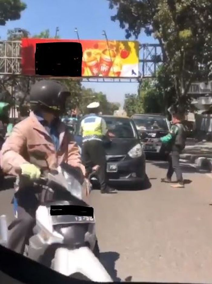 Polisi dibantu pengendara sekitar menghentikan sang pelanggar