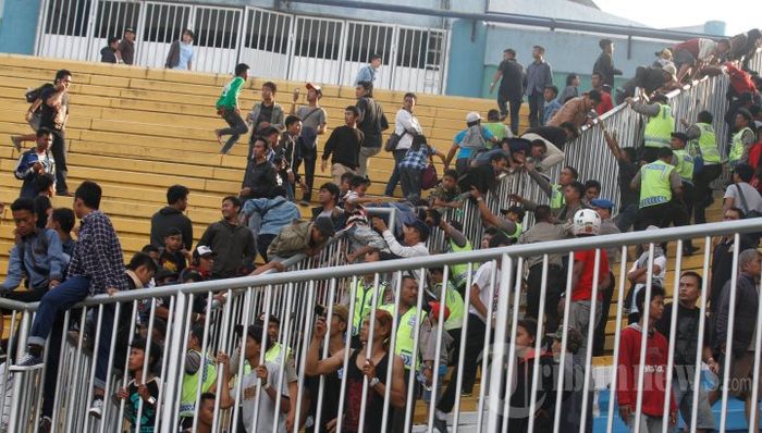 Anggota kepolisian berusaha mengevakuasi sejumlah suporter saat terjadi kerusuhan antar suporter pada laga lanjutan Liga Super Indonesia (LSI) antara Persija Jakarta melawan Persib Bandung di Stadion Maguwoharjo, Sleman, DI Yogyakarta, Rabu (28/8/2013).