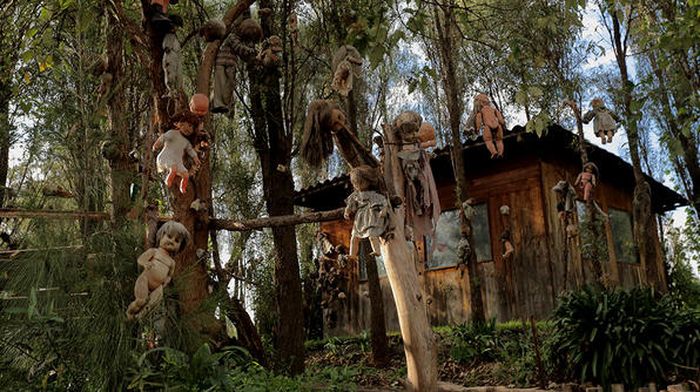 Sebuah gubuk di pulau itu di depannya ada banyak boneka.